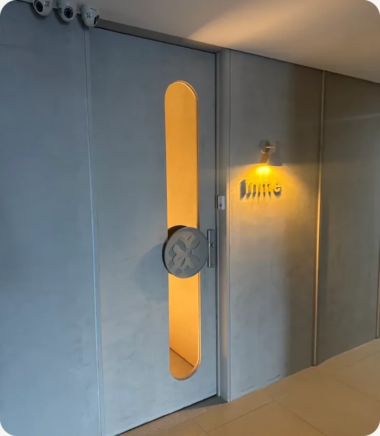 Porta de acesso do INME em azul-acinzentado, com puxador dourado vertical