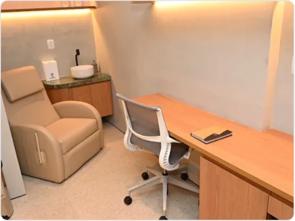 Sala de atendimento do INME com poltrona reclinável e mesa de trabalho